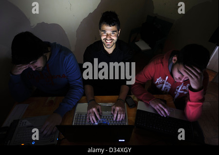 Tre giovani uomini utilizzando computer portatili Foto Stock