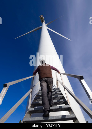 Uomo accanto alla turbina eolica Foto Stock