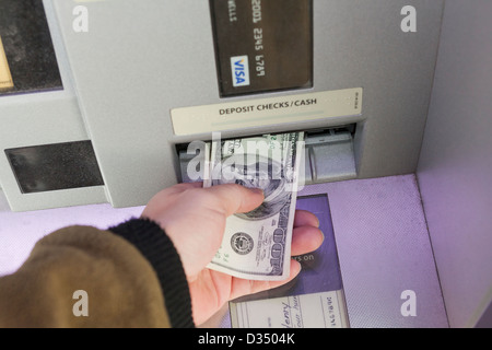 L'uomo depositare denaro in ATM Foto Stock