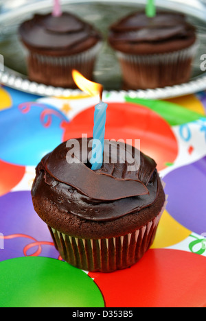 Tortina di cioccolato con luce blu fissa candela Foto Stock