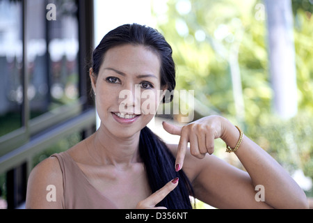 40 anno vecchia donna Thai attirando l' attenzione di fresco e ben curati dipinto di unghie. Thailandia SUDEST ASIATICO Foto Stock