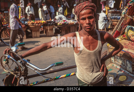 Ritratto di un ciclista che si trova accanto al suo risciò, Dhaka, Bangladesh Foto Stock