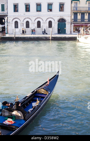 Gondola tradizionali a fondo piatto veneziano barca a remi lungo il Canal Grande a Venezia Italia Foto Stock