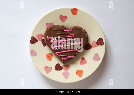 San Valentino cuore di cioccolato torta a forma di cuore sulla torta cuori piastra isolata su sfondo bianco - ideale per il giorno di San Valentino, il giorno di San Valentino Foto Stock