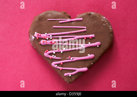 San Valentino cuore di cioccolato torta a forma di cuore isolato di torta su sfondo rosa - ideale per il giorno di San Valentino, il giorno di San Valentino Foto Stock