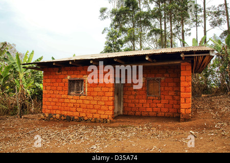 Tipica terra rossa o mattoni di suolo con Tin Roof casa per i lavoratori e simili, in Africa. Foto Stock