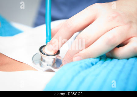 Medico chirurgo tenendo il suo stetoscopio Foto Stock