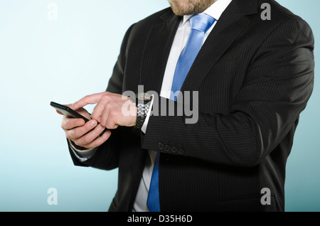 Imprenditore utilizzando smart phone. Sezione centrale di casualmente adatto uomo con un touch screen telefono cellulare con il suo dito. Foto Stock