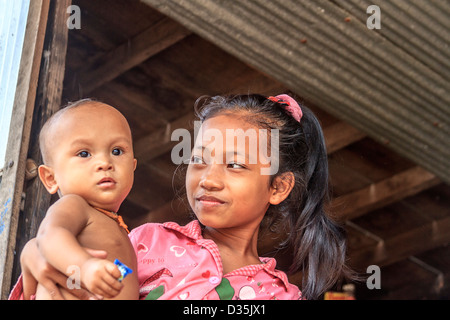 Ragazza giovane e un neonato in Kompong Pluk (Phluk), un gruppo di tre palafitta villaggi vicino a Siem Reap, Cambogia Foto Stock