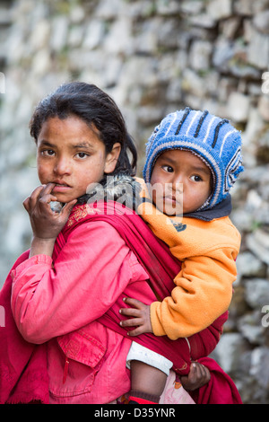 Una giovane ragazza Nepalese con il suo fratellino in Himalaya, Nepal. Foto Stock