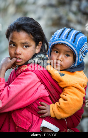 Una giovane ragazza Nepalese con il suo fratellino in Himalaya, Nepal. Foto Stock