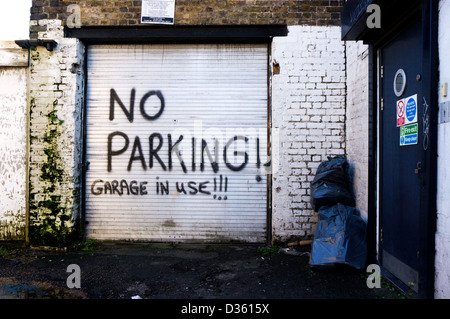 Nessun parcheggio! Garage in uso!!! Segno verniciato a spruzzo sul rullo porta ad otturatore. Foto Stock