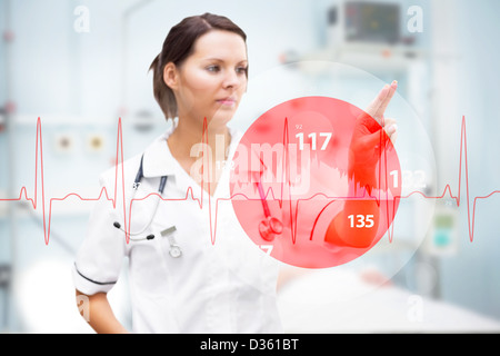 Infermiere rivolto a schermo invisibile con digital rosso linea ECG in primo piano Foto Stock