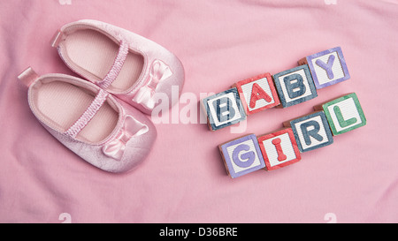 Baby girl enunciato in blocchi con scarpine rosa Foto Stock