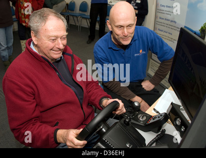 Uomo che partecipa alla giornata di sensibilizzazione ambientale utilizzando un simulatore di computer per imparare a guidare in modo più ecologico, Bordon, Hants, Regno Unito. Foto Stock