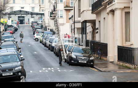 Uomo che porta una lunga scala vicino a Brighton Royal Sussex County Hospital RSCH Foto Stock