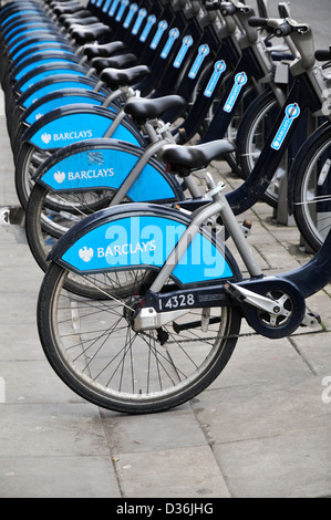 Fila di London cycle noleggiare biciclette in una docking station Foto Stock