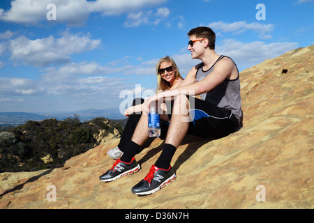 Amici seduti su Eagle Rock a Topanga State Park in Topanga, California Foto Stock