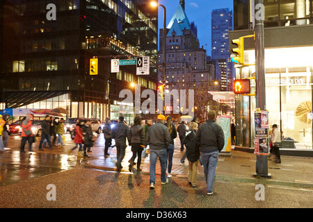 Persone angolo di incrocio di Granville e West Georgia strade su una notte piovosa Vancouver BC Canada Foto Stock