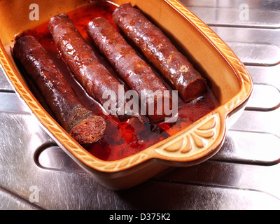 Salsicce fatte in casa cotto in un recipiente di ceramica. Foto Stock