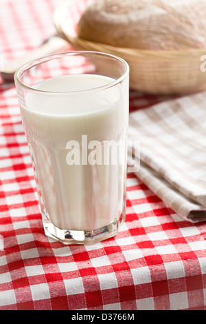 Il bicchiere di latte sulla tovaglia a scacchi Foto Stock