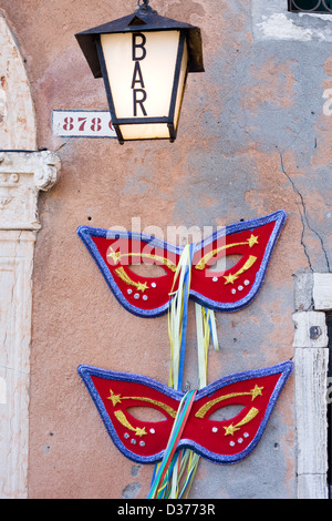 Grandi semimaschere esterno su una parete bar a Venezia Italiy Foto Stock
