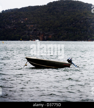 Piccola barca con motore fuoribordo in un lago Foto Stock