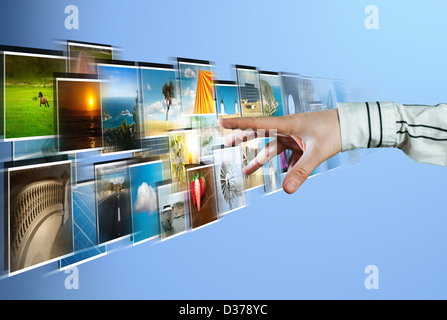 La mano di raggiungere lo streaming di immagini dal profondo su sfondo blu Foto Stock