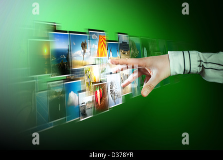 La mano di raggiungere lo streaming di immagini dal profondo su sfondo verde Foto Stock