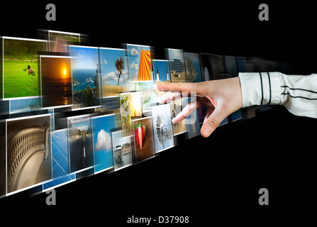 La mano di raggiungere lo streaming di immagini dal profondo su sfondo nero Foto Stock