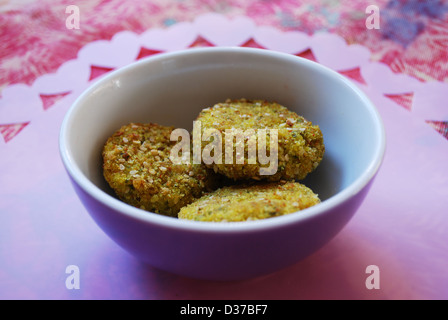 Tre miglio vegetariano polpette di carne in una piccola violetta cina ciotola, Cuori rosa in background Foto Stock