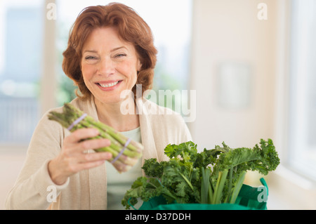 Stati Uniti d'America, New Jersey, Jersey City, Senior donna con negozi di generi alimentari in cucina Foto Stock