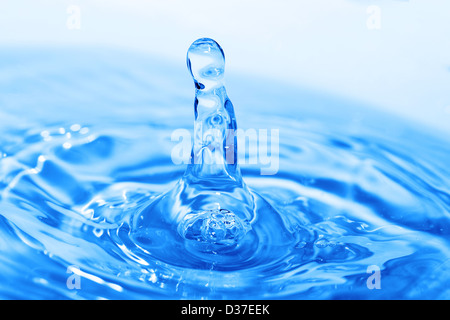Schizzi di acqua sulla superficie blu Foto Stock