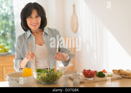 Stati Uniti d'America, New Jersey, Jersey City, Senior donna insalata di preparazione Foto Stock