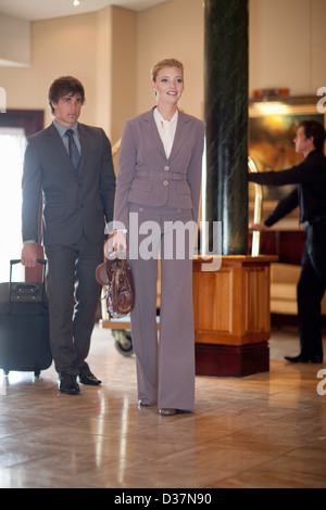 La gente di affari a piedi nella hall hotel Foto Stock