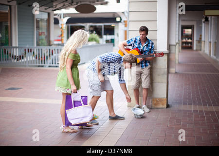 L'uomo modifica dando al lettore di chitarra Foto Stock