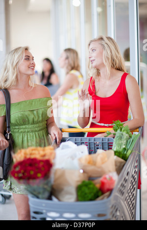 Donne spingendo carrello Foto Stock