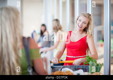 Donne spingendo carrello Foto Stock