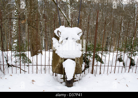 Retrò giardino arrugginito barrow attrezzo coperte di neve in inverno. Foto Stock