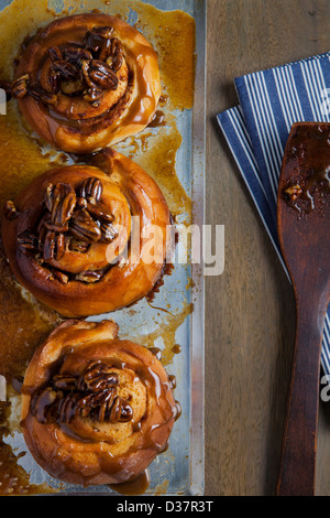 Le ciambelle glassate sul vassoio di cottura Foto Stock