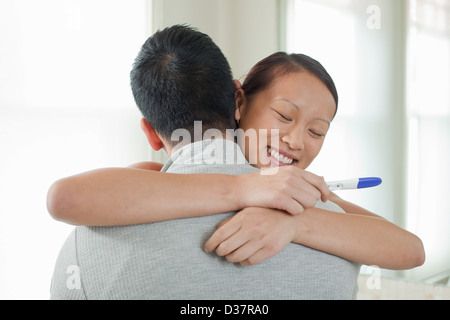 Coppia felice tenendo al test di gravidanza Foto Stock