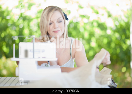 Donna al lavoro su macchina da cucire Foto Stock