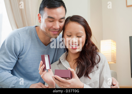 L uomo dando ragazza dono sul divano Foto Stock