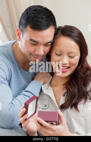 L uomo dando ragazza dono sul divano Foto Stock