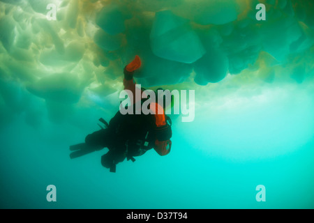 L'uomo scuba diving sotto il ghiacciaio Foto Stock