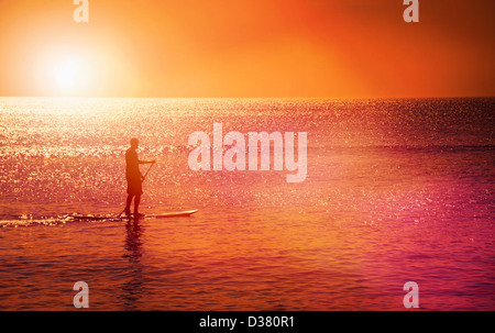 Stati Uniti d'America, North Carolina, nag Testa, uomo in piedi sulla scheda di racchetta al tramonto Foto Stock