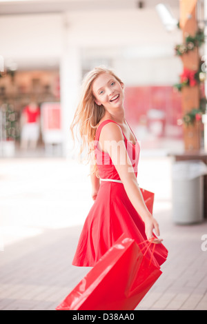 La donna il trasporto delle borse della spesa in mall Foto Stock