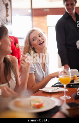 Le donne aventi insieme per la prima colazione nella caffetteria Foto Stock