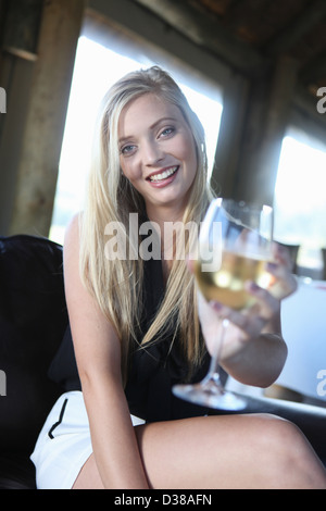 Donna che offre un bicchiere di vino Foto Stock