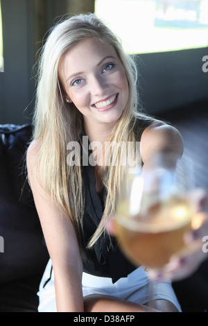 Donna che offre un bicchiere di vino Foto Stock